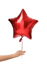 Woman hand give single big red star latex balloon for birthday party isolated on a white Royalty Free Stock Photo