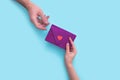 Woman hand gives an envelope with a heart to a man in hand on a pink background. valentines day Royalty Free Stock Photo