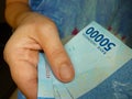 Woman hand giving away some money, Indonesian banknotes