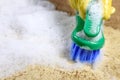 Woman hand in glove cleans carpet in the room, using brush. Close up. Cleaning concept Royalty Free Stock Photo