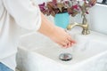 The woman hand is going to open the faucet to wash hands. To maintain cleanliness after entering the bathroom, the concept of Royalty Free Stock Photo