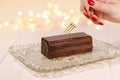 Woman hand with golden fork taking peace of chocolate cake