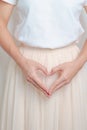 Woman hand heart shape over abdomen. Ovarian and Cervical cancer, Endometriosis, Hysterectomy, Uterine fibroids, Reproductive, Royalty Free Stock Photo