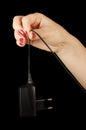 Woman hand hold black cell phone charger Royalty Free Stock Photo