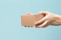 Woman hand hold the brown corrugate box on blue wall background with copy space Royalty Free Stock Photo