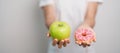 woman hand hold green Apple and donut, female fitness choose between fruit is Healthy and sweet is Unhealthy junk food. Dieting