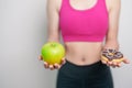 woman hand hold green Apple and donut, female fitness choose between fruit is Healthy and sweet is Unhealthy junk food. Dieting Royalty Free Stock Photo