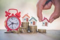 Woman hand hold a home model put on the stack coin with growing in the public park, Savings money for buy house and loan to