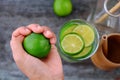 Woman hand hold lemons and lime slices for detox water Royalty Free Stock Photo