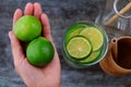 Woman hand hold lemons and lime slices for detox water Royalty Free Stock Photo