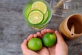 Woman hand hold lemons and lime slices for detox water Royalty Free Stock Photo