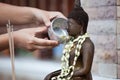 Woman hand hold little bowl to bath Buddha statue Royalty Free Stock Photo