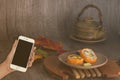 Woman hand hold smart phone on blurred japanese sushi set Royalty Free Stock Photo