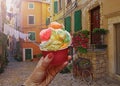 Woman hand hold sweet ice - cream cone with different flavors held in hand in Rovinj