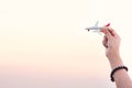 Woman hand holding airplane model in sunset sky and summer sea b Royalty Free Stock Photo