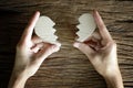 Woman hand holding broken heart paper cut on wooden background Royalty Free Stock Photo