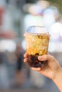 woman hand holding brown sugar boba milk tea with tapioca pearls at night market, famous Taiwanese bubble tea of Taiwan. Street Royalty Free Stock Photo