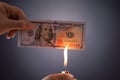 Woman hand holding burning burning dollar cash money over black background - business finances, savings and bankruptcy concept Royalty Free Stock Photo