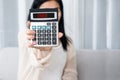 Woman hand holding calculator showing word debt , bankruptcy, financial problem concept