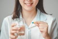 Woman hand holding capsule pill and glass of water Royalty Free Stock Photo