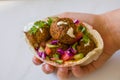 Woman hand holding chickpea Falafel balls in a pitta bread