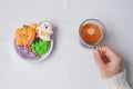 woman hand holding coffee cup during eating funny Halloween Cookies. Happy Halloween day, Trick or Threat, Hello October, fall Royalty Free Stock Photo