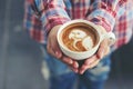 Woman hand holding coffee latte art with pattern the parrot in c Royalty Free Stock Photo