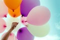 Woman hand holding colorful balloons on blue sky background Royalty Free Stock Photo