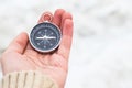 Woman hand holding compass against light blurred background. Hiking traveler equipment. Navigation for travel. Find way and