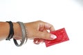 Woman hand holding condom on isolated white cutout background. Studio photo can illustrate hpv std gonorrhea, chlamydia