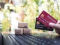 Woman hand holding credit cards and carton boxs on a laptop keyboard. Concepts about online shopping that offers home delivery Royalty Free Stock Photo