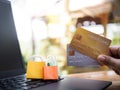 Woman hand holding credit cards and shopping bags on a laptop keyboard. Concepts about online shopping that offers home delivery Royalty Free Stock Photo