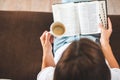 Woman hand holding cup of coffee and reading Holy bible Royalty Free Stock Photo