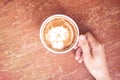 Woman hand holding cup of coffee. Top view. Cute latte art, cat Royalty Free Stock Photo