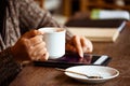 Woman hand holding the cup of coffee and using digital tablet Royalty Free Stock Photo