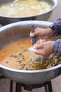 Woman hand holding dipper scooping freshwater snail in red curry Put in a plastic bag Royalty Free Stock Photo