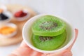 Woman hand holding dried fruit kiwi slices in white bowls. Organic healsy healthy snack. Selective focus