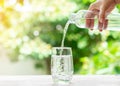 Woman hand holding drinking water bottle pouring into glass Royalty Free Stock Photo