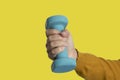 Woman hand holding dumbbell on yellow background. Equipment for workout. Fitness and activity.Power ,success, sport and healthy