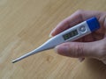 Woman hand holding electric clinical thermometer showing high fe Royalty Free Stock Photo