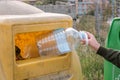 Woman hand holding empty big plastic bottle into container. Royalty Free Stock Photo