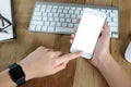 Woman hand holding empty screen of smart-phone on wood desk work