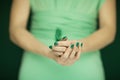 Woman hand holding exotic bird feather, sensual studio shot in green Royalty Free Stock Photo