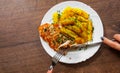 Woman hand holding fork and knife with Grilled chicken breast with potato in a plate on a wooden background Royalty Free Stock Photo