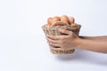 Woman hand holding fresh eggs collected inside wicker basket, suitable as a food ingredient or giving present. Royalty Free Stock Photo