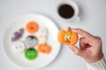 Woman hand holding funny Halloween Cookie during drinking coffee. Happy Halloween day, Trick or Threat, Hello October, fall autumn Royalty Free Stock Photo