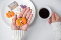 Woman hand holding funny Halloween Cookie during drinking coffee. Happy Halloween day, Trick or Threat, Hello October, fall autumn Royalty Free Stock Photo