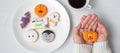 Woman hand holding funny Halloween Cookie during drinking coffee. Happy Halloween day, Trick or Threat, Hello October, fall autumn Royalty Free Stock Photo