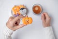 Woman hand holding funny Halloween Cookie during drinking coffee. Happy Halloween day, Trick or Threat, Hello October, fall autumn Royalty Free Stock Photo