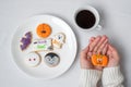 woman hand holding funny Halloween Cookie during drinking coffee. Happy Halloween day, Trick or Threat, Hello October, fall autumn Royalty Free Stock Photo